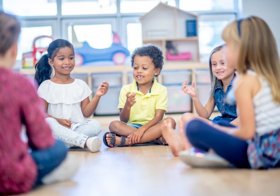 kindergarteners-playing-a-game Children sit in a circle and play a game at the best preschool for Elmwood IL children, Embrace Life Child Care.