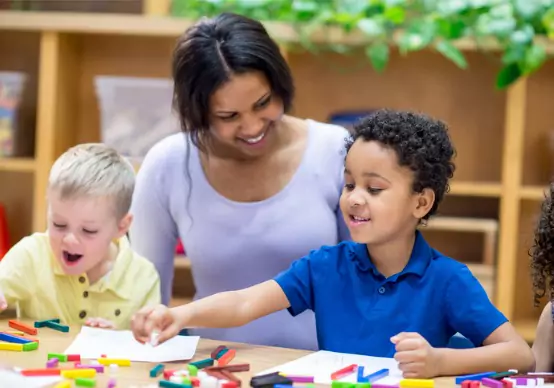 creative-construction A teacher at Embrace Life Child Care, a great option for Pre-K by Elmwood IL, helps kids work on a project.