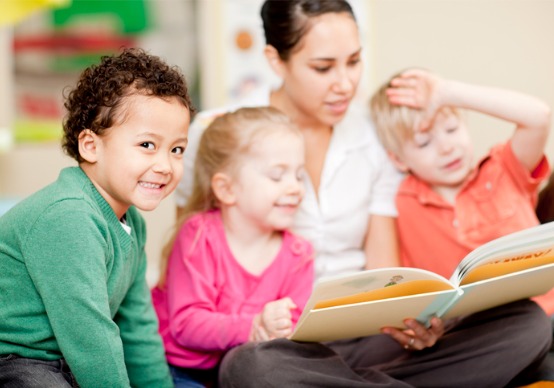 preschool-daycare A teacher at Embrace Life Child Care, the Best Preschool in Peoria County IL, reads to children in her class.