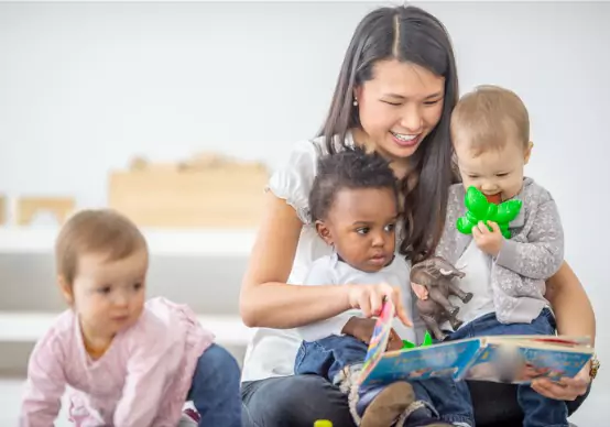 preschool-teacher-reads-a-book-to-her-students A teacher at Embrace Life Child Care, a top option for Pre-K by Peoria IL, reads to babies in class.