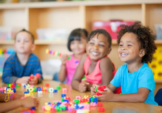 preschool Children at Embrace Life Child Care, which is a great option for Pre-K by Princeville IL, smile while playing with toys.