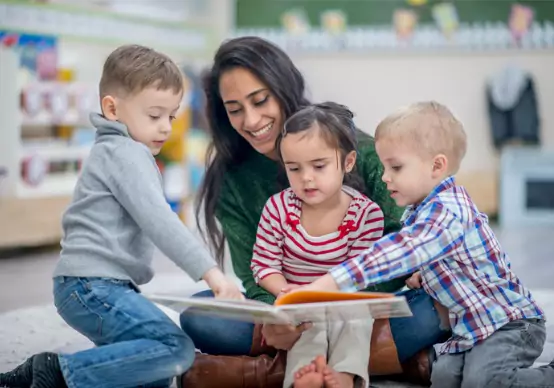 reading-together A teacher at Embrace Life Child Care, which offers Pre-K by Peoria IL, reads to children in class