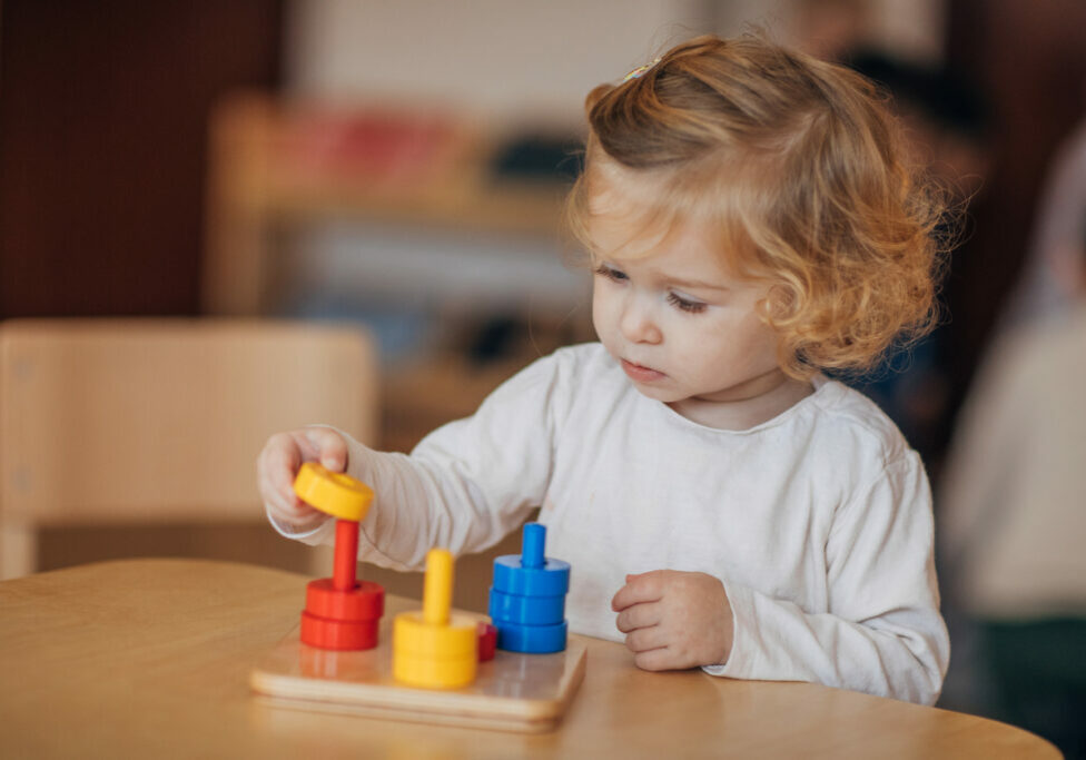Little girl playing with a toy that helps her develop her critical thinking skills