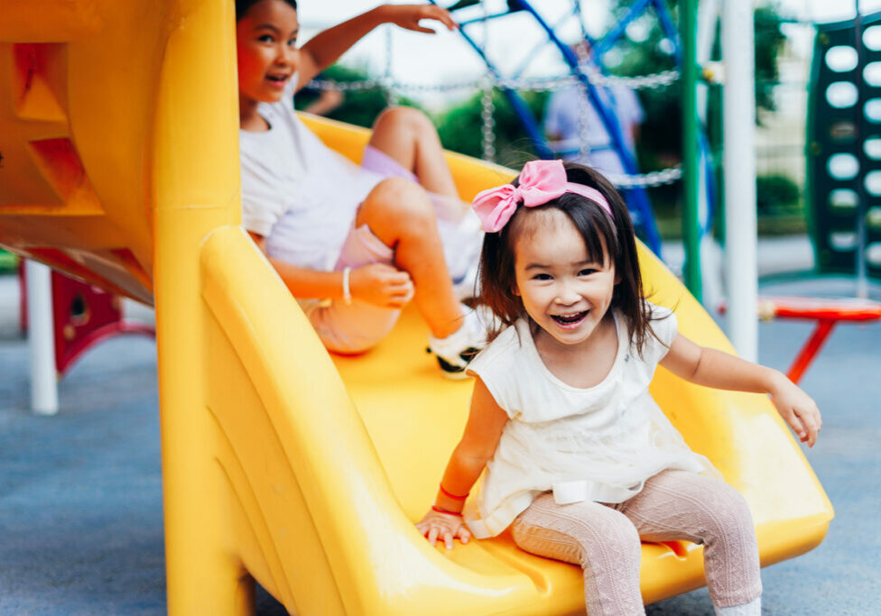 Two girls playing and staying active in a playground