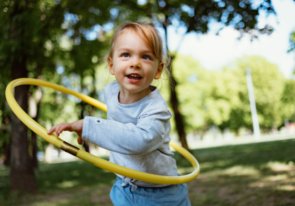 Little girl playing with a hula hoop