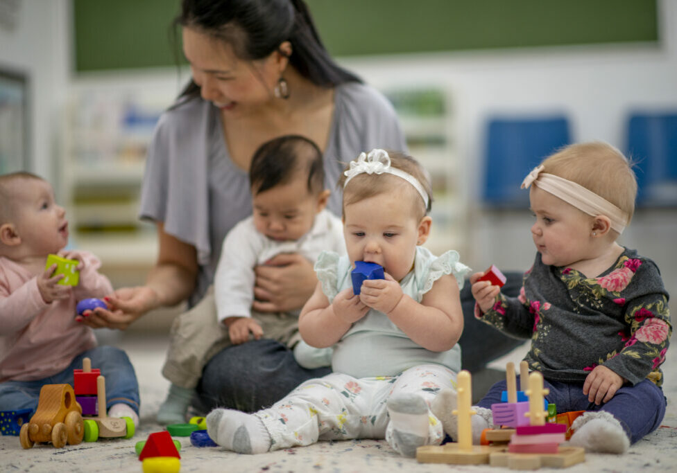 Babies playing with blocks and socializing with each other