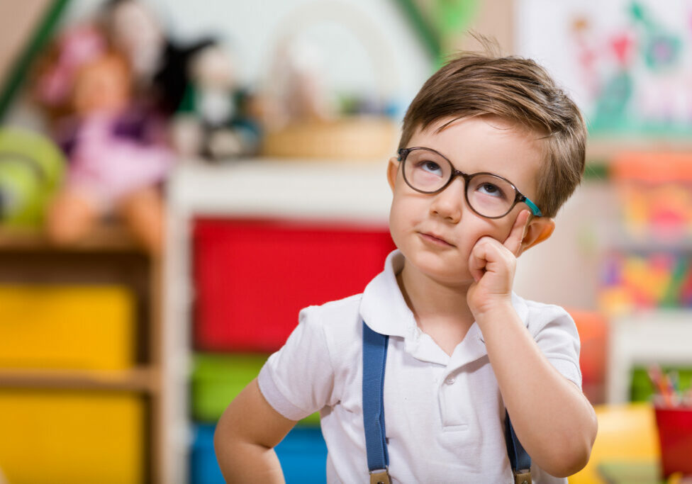 Cute preschool boy looking up and thinking